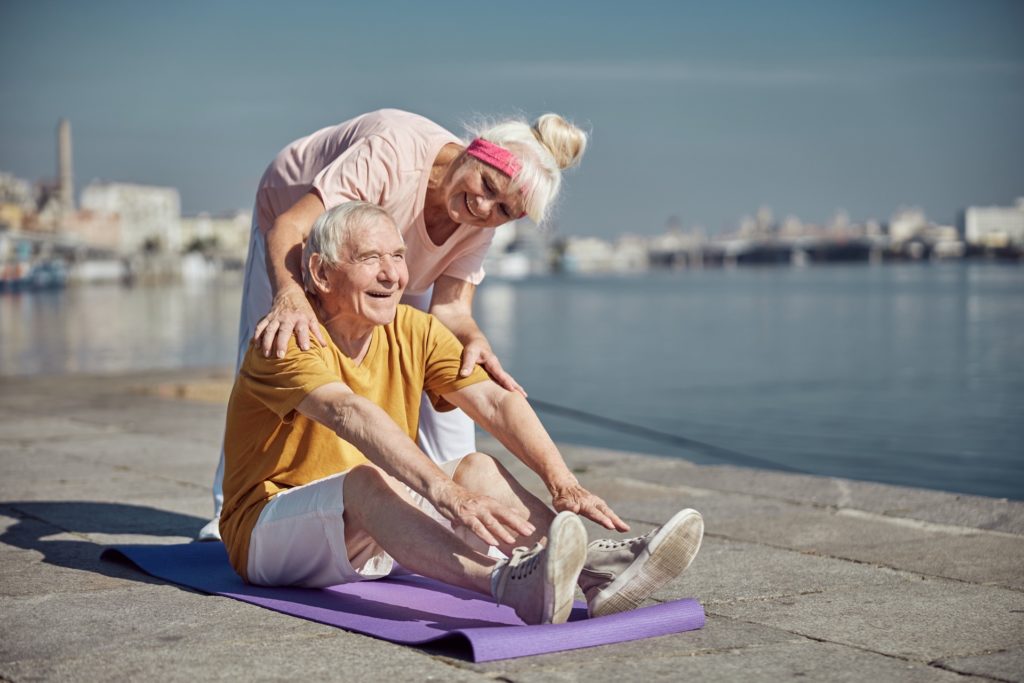 gioioso uomo anziano che fa un esercizio di stretching