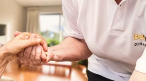 BeeCare-Mitarbeiterin hält die Hand einer älteren Person und bietet dadurch Unterstützung und Geborgenheit bei der häuslichen Pflege.